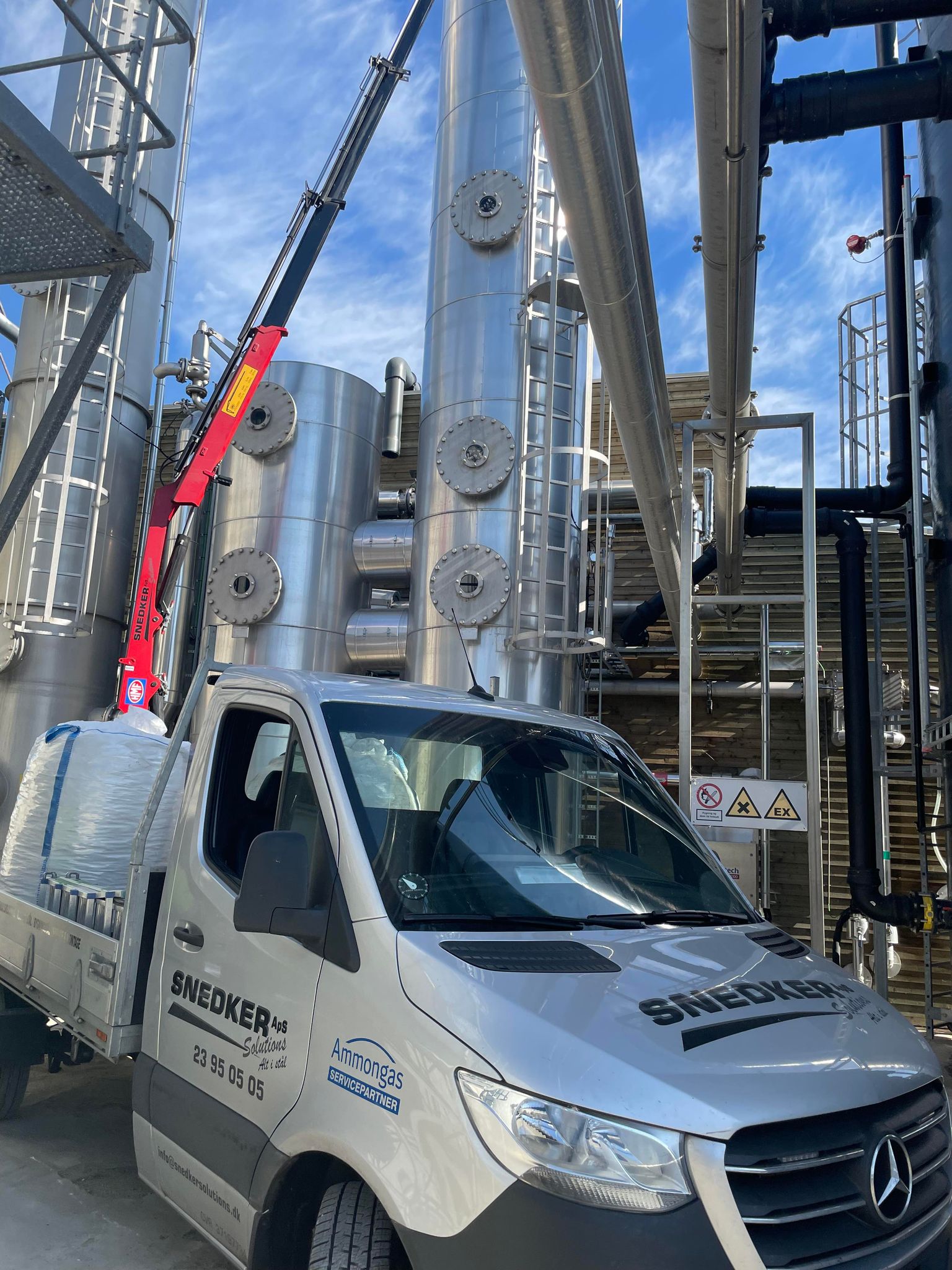 Lastbil ved industrielt anlæg med stålrør