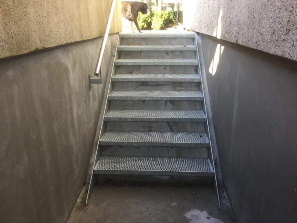 Metaltrappe op til gård med hund